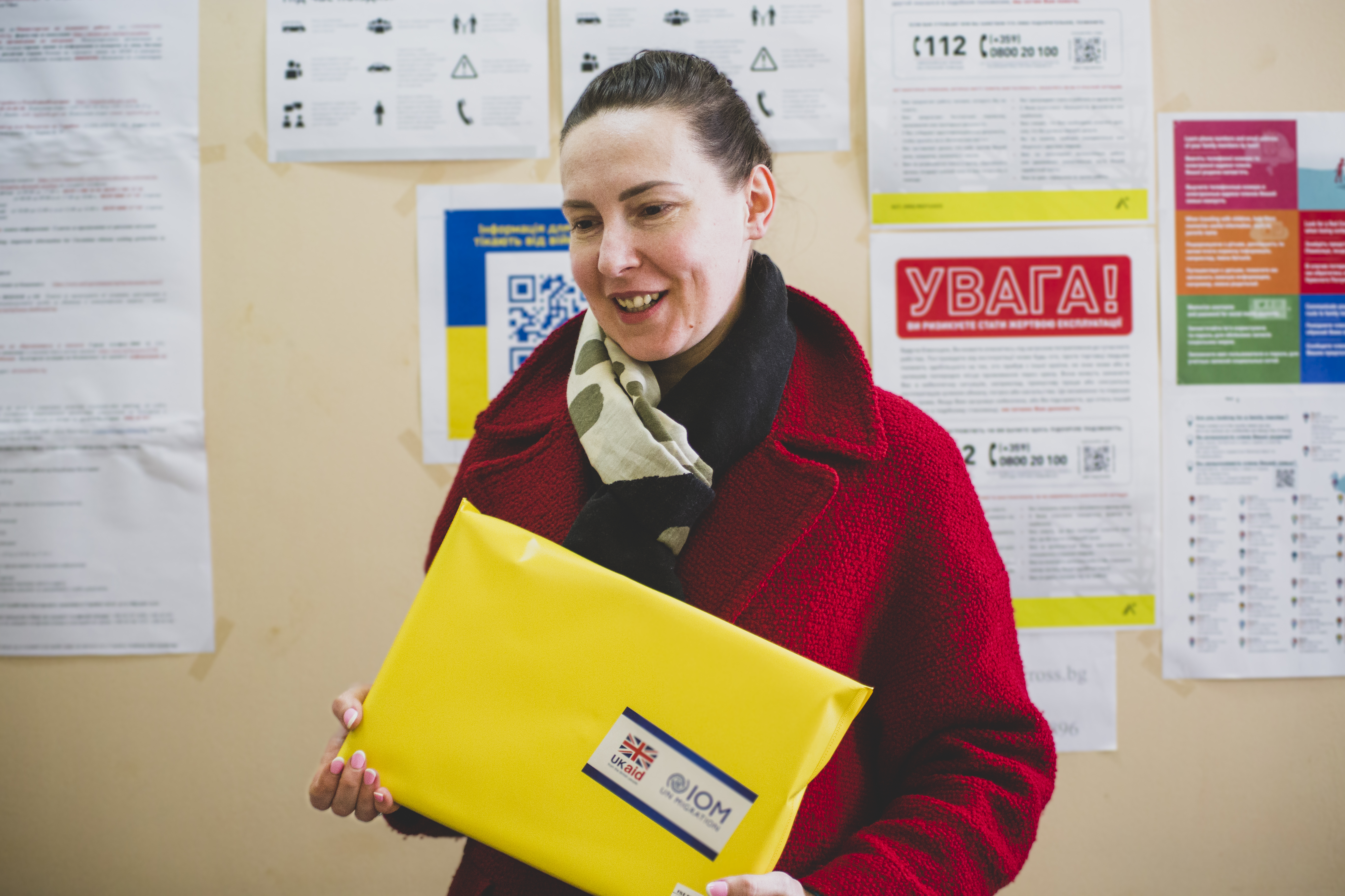 A woman fleeing the war in Ukraine with a school supplies kit from IOM