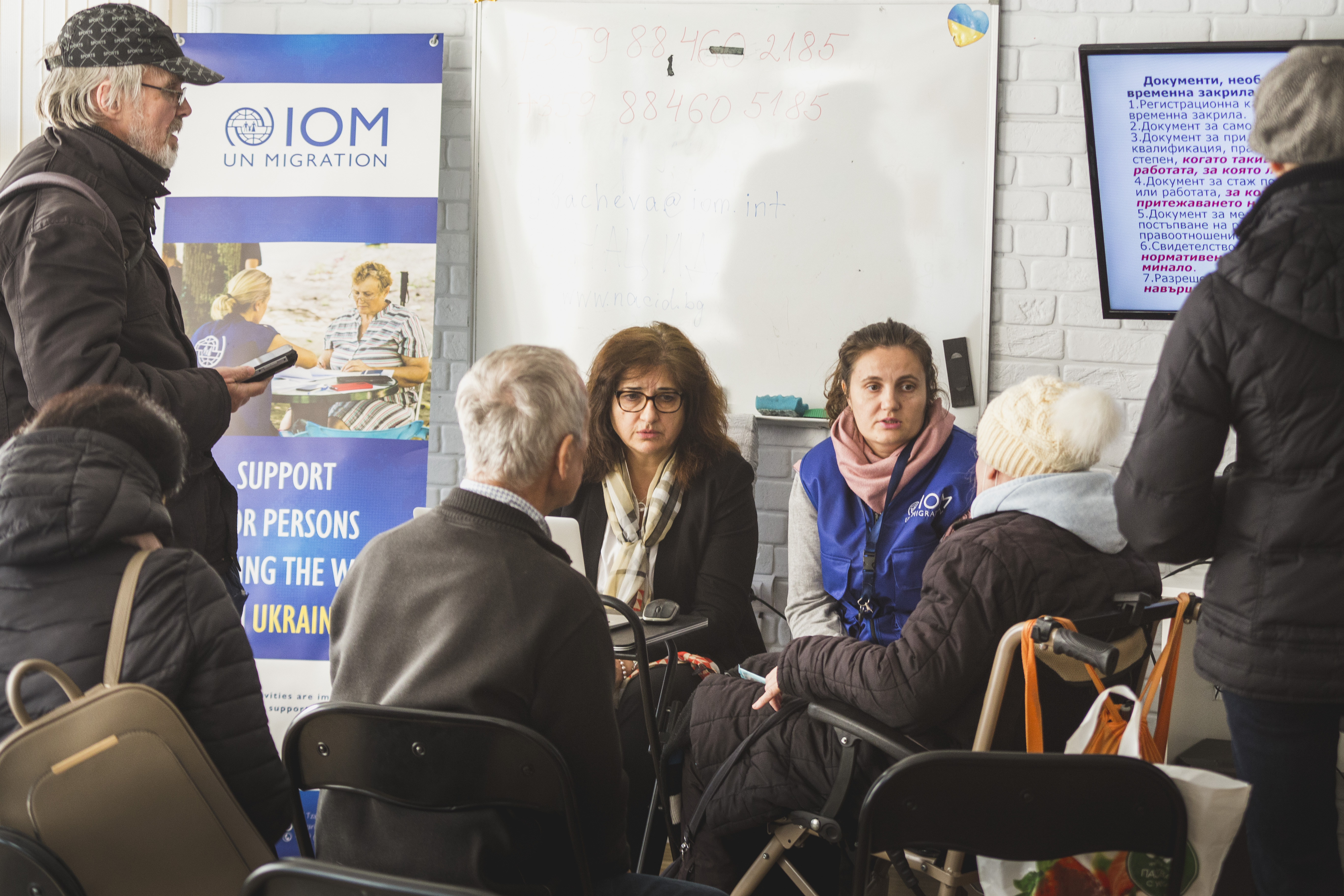 IOM staff talking to a refugee from Ukraine with disabilities