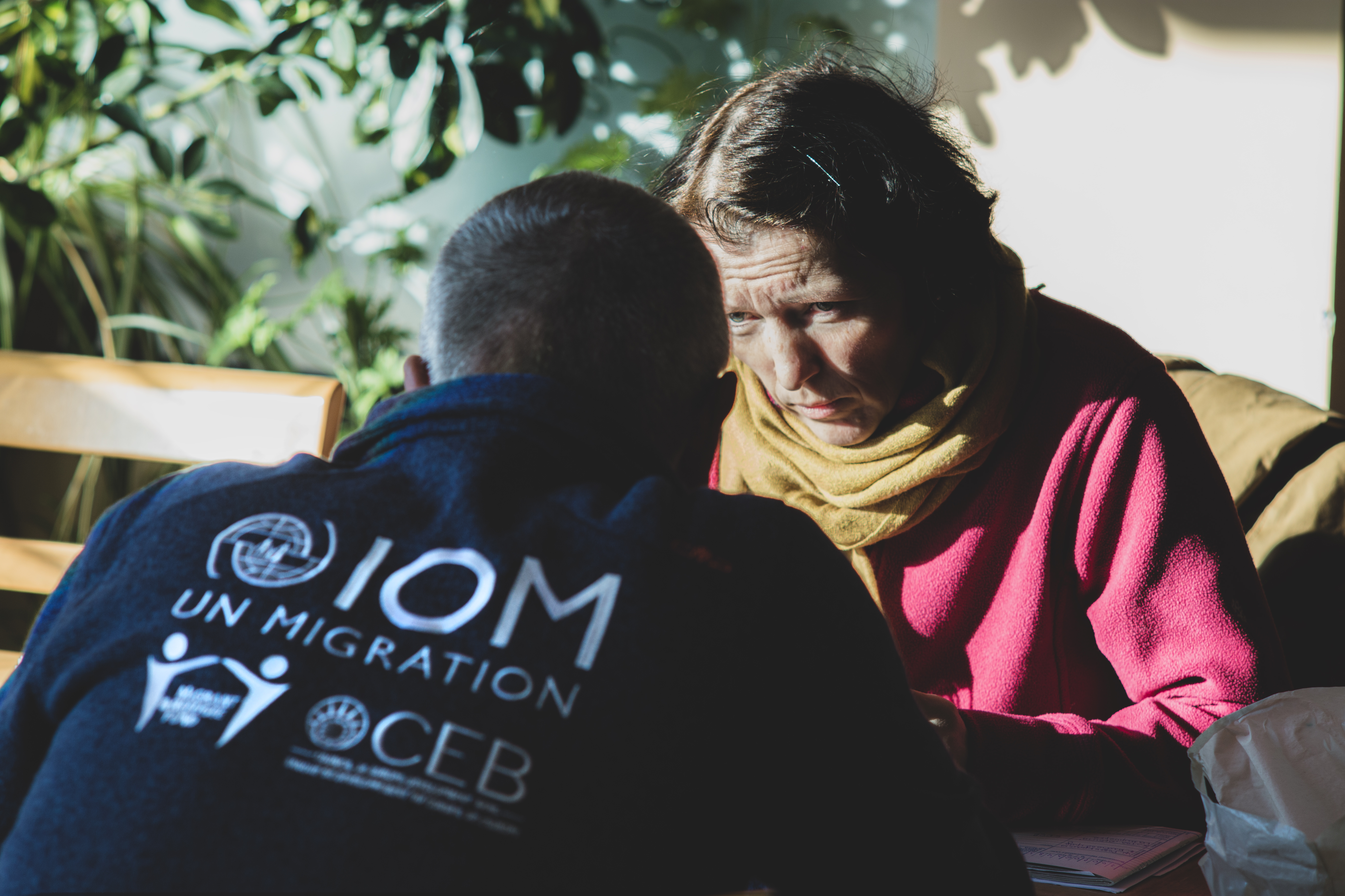 A woman from Ukraine in front of an IOM team member