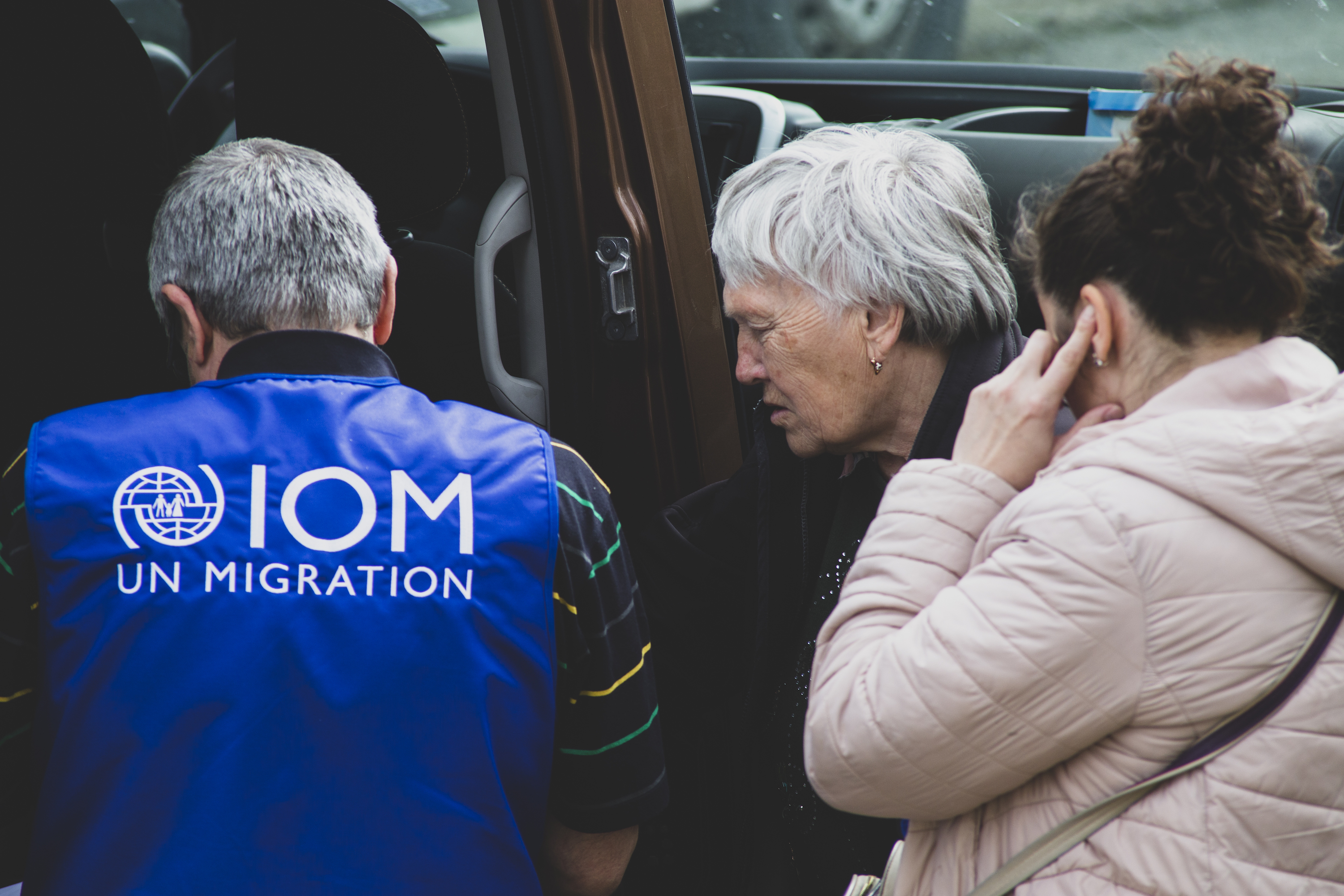 IOM staff and an elderly lady from Ukraine